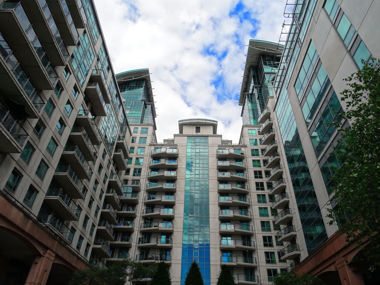 our-story-01 Low angle view of modern glass skyscrapers with a blue sky backdrop, highlighting architectural design.